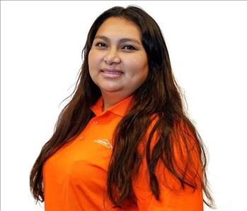 Female employee in SERVPRO shirt in front of white backdrop